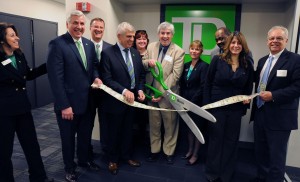 Annalisa Russell-Smith |    Using a ribbon made from real bank notes, New Britain Mayor, Tim O'Brien, center, officially opens the new offices of TD Bank at 178 Main Street Thursday. TD Bank executives from left, Ale Federico, Michael LaBella, John Cookley, Mauro DeCarolis, Kelly McBride, O'Brien, Diane Eschner, Carl Hinds, Sheila Amaral and Bill Carroll of the Greater New Britain Chamber of Commerce.