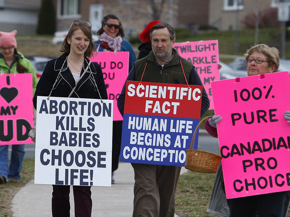 Pro-choice group Love Team Peterborough march carrying bright pink signs alongside the Peterborough Pro-Life group outside Peterborough Regional Health Centre (PRHC) on Saturday April 15, 2017 in Peterborough, Ont. Love Team Peterborough was formed in December. Crystal Mosey, a respite-care worker, started the group with two of her friends. Every Saturday morning since Dec. 10, they've gone to PRHC with signs voicing their concerns. CLIFFORD SKARSTEDT/PETERBOROUGH EXAMINER/POSTMEDIA NETWORK